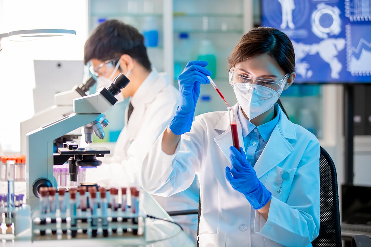 Scientists looking at blood samples in a lab. 