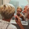 Elderly man brushing wife's teeth cropped Elderly man brushing wife's teeth cropped