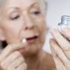Senior woman holding a bottle of pills Senior woman holding a bottle of pills