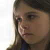 Girl looking skeptically at a peanut Girl looking skeptically at a peanut
