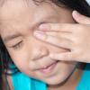 Young girl rubbing her eye