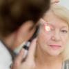 Eye doctor giving an older woman an eye exam Eye doctor giving an older woman an eye exam
