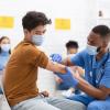A young man getting a vaccination in a hospital setting