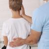 Child getting his back examined by a health care professional Child getting his back examined by a health care professional