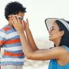 A mother putting sunglasses on her child A mother putting sunglasses on her child.