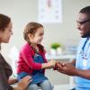A young child and her mom talking with a doctor in the clinic A young child and her mom talking with a doctor in the clinic.