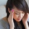 Woman holding her head in pain.