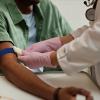 Nurse preparing patient's arm for blood test.