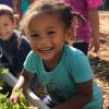 Young children tending to plants in a community garden, image was AI-generated