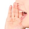 Women holding hand over mouth shouting Women holding hand over mouth shouting