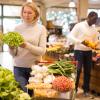 Middle-aged woman shopping for fresh vegetables.