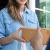 Woman being handed a package by a delivery person.