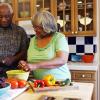Older adult couple preparing healthy food together in the kitchen.