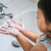 Young girl washing her hands.