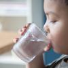 Child drinking a glass of water.