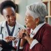 A health care provider showing a patient a tablet.