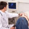 Doctor performing an ultrasound on a patient.