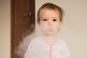 Young girl in a cloud of cigarette smoke