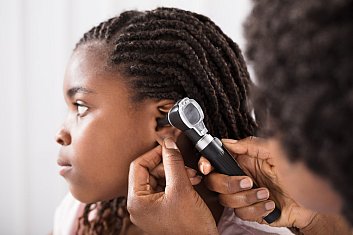 Young girl getting ears checked by her health care provider