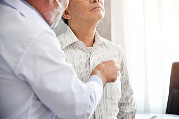 Doctor listening to an older patient's chest with a stethoscope