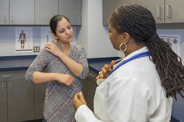 Patient discussing shoulder pain with her doctor