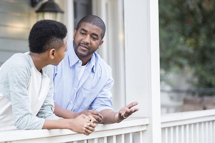Father talking with his son on the porch