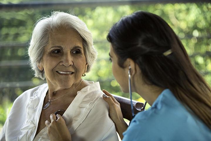 Physician listens to her senior patient's heart