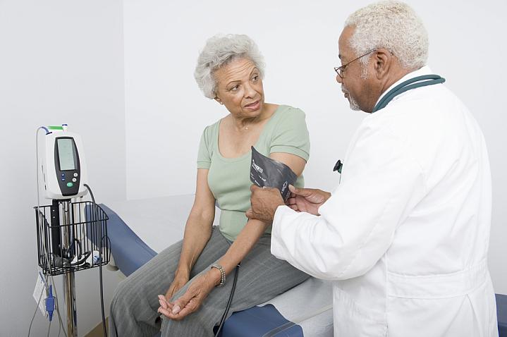 Doctor measuring blood pressure of a senior black woman