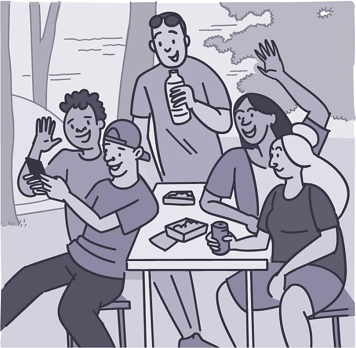 Group of friends taking a selfie outside at a picnic table